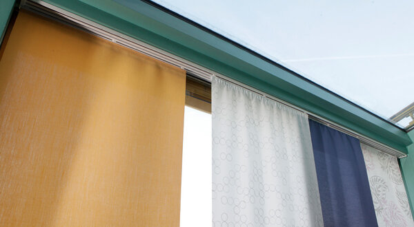 Schiebevorhang in der Ausstellung Aussigstraße mit drei Musterstoffen in beige, weiß und blau