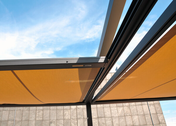 Q.Bus System mit antrazitfarbendem Metallgestell und verfahrbaren Stofftüchern in beigebraun auf einer Dachterrasse