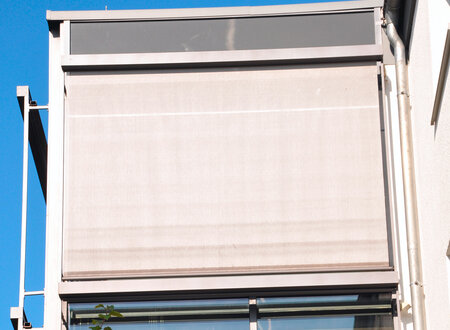 Senkrechtmarkise in lichtgrau an der seitlichen Front eines Wintergartens